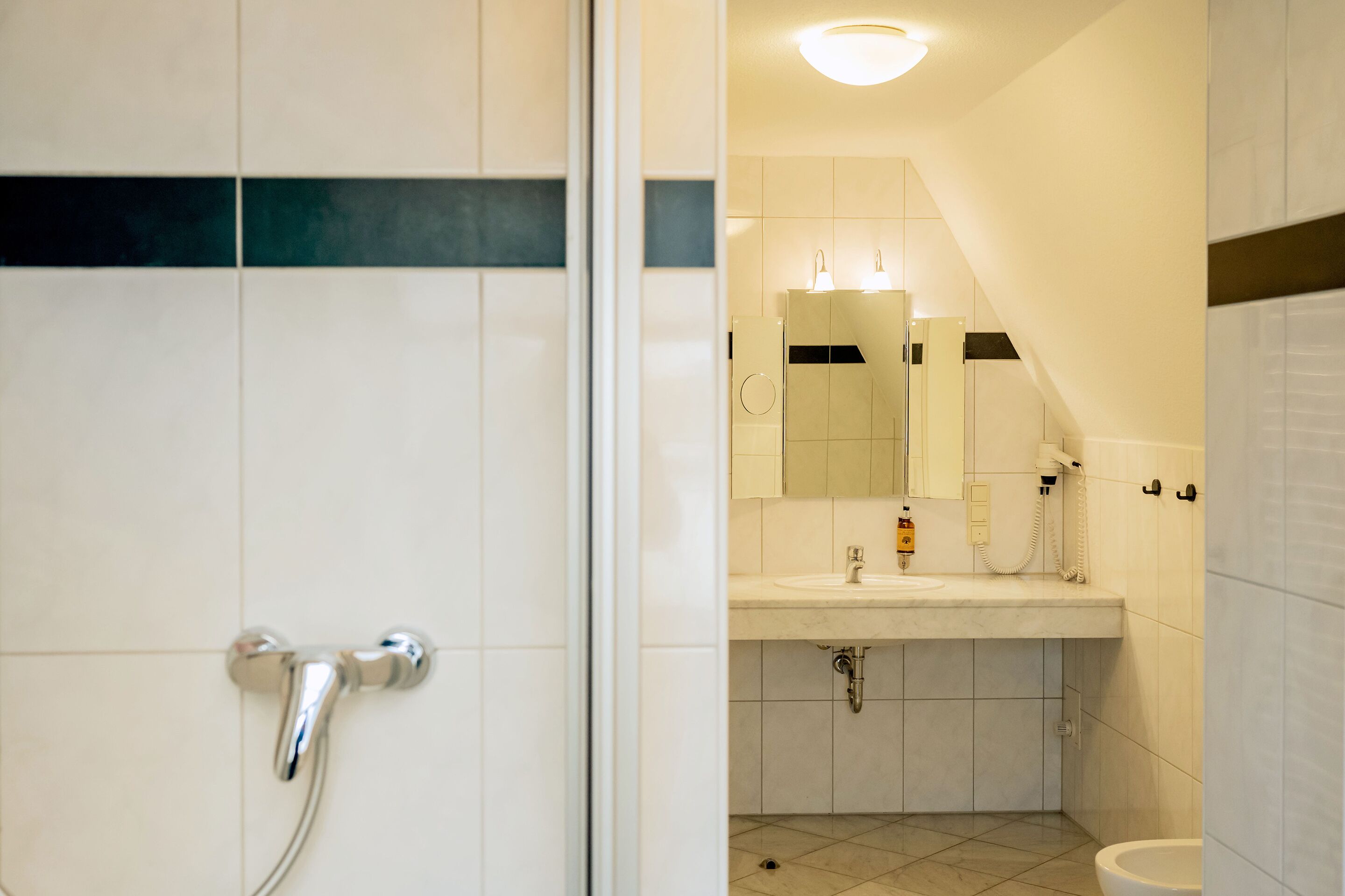 A bathroom with a shower, sink, and toilet.