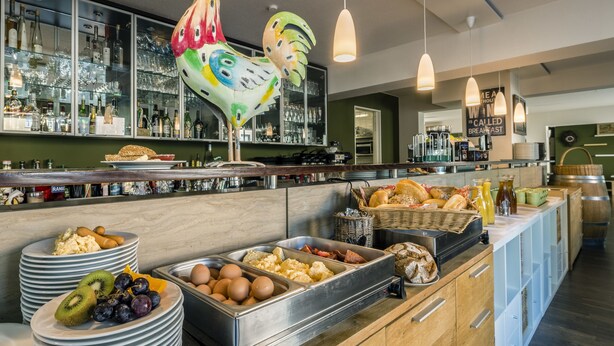 A breakfast buffet with various food items and a large decorative rooster. - Apparthotel Steiger Bad Schandau (Bad Schandau)