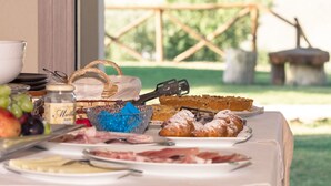 Una mesa de desayuno con diferentes alimentos, una cesta y un frasco de mermelada.