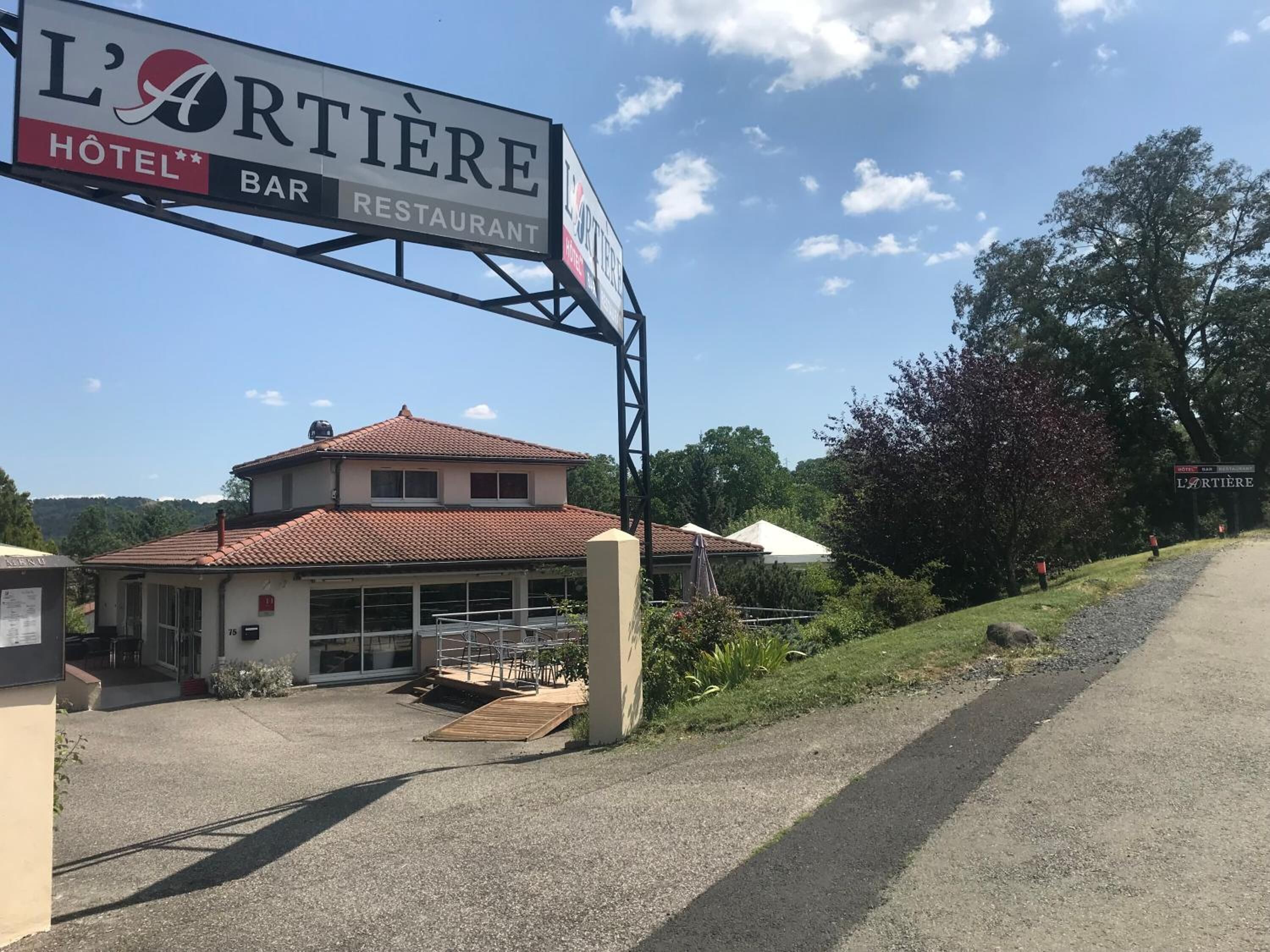 A building with a sign for 'L'ARTIERE HOTEL BAR RESTAURANT'.