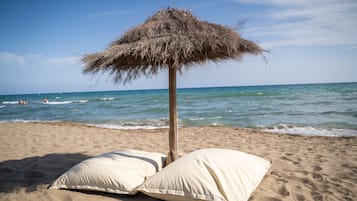 Een privéstrand, ligstoelen aan het strand, parasols