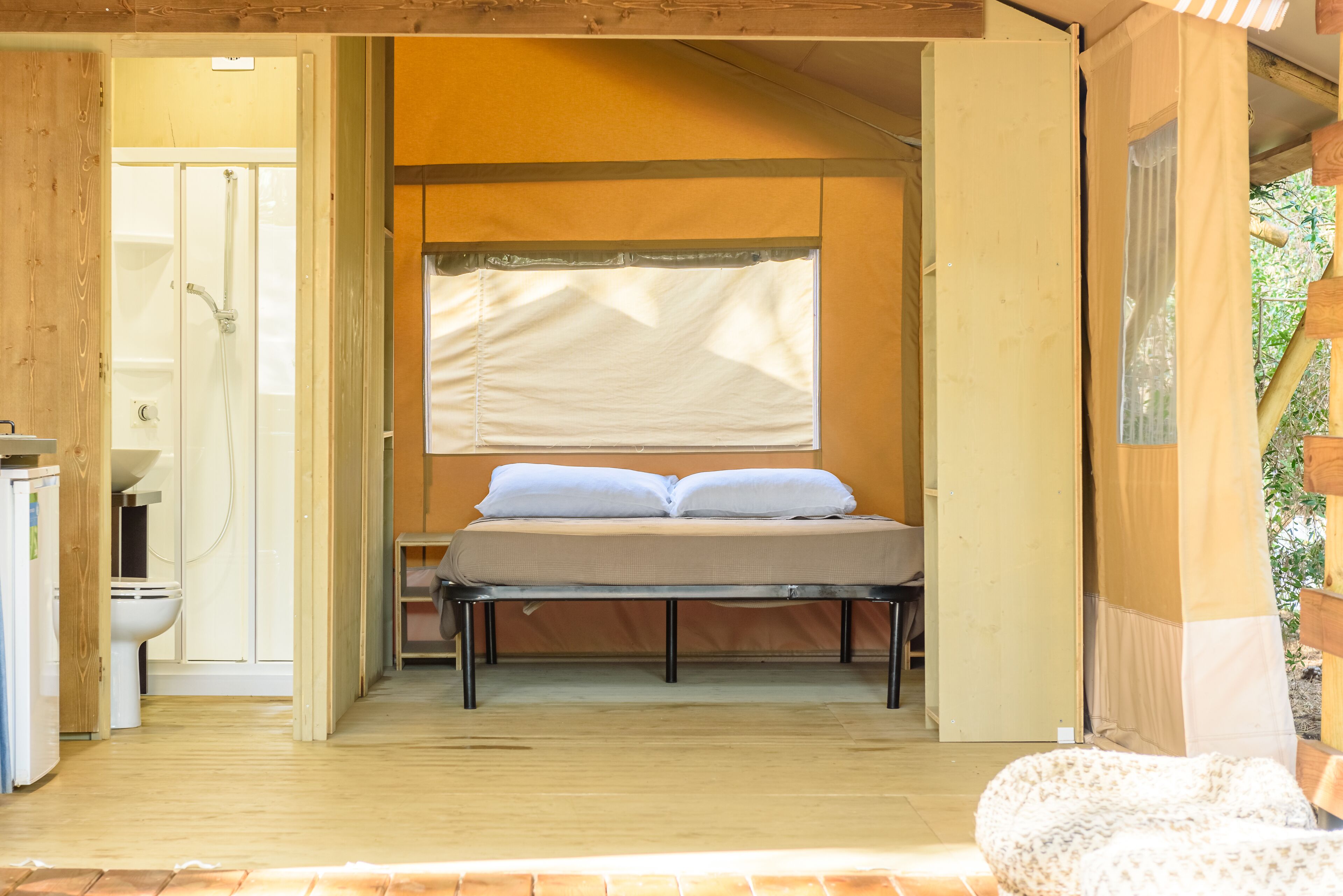Una habitación pequeña y acogedora con cama, inodoro y zona de ducha.