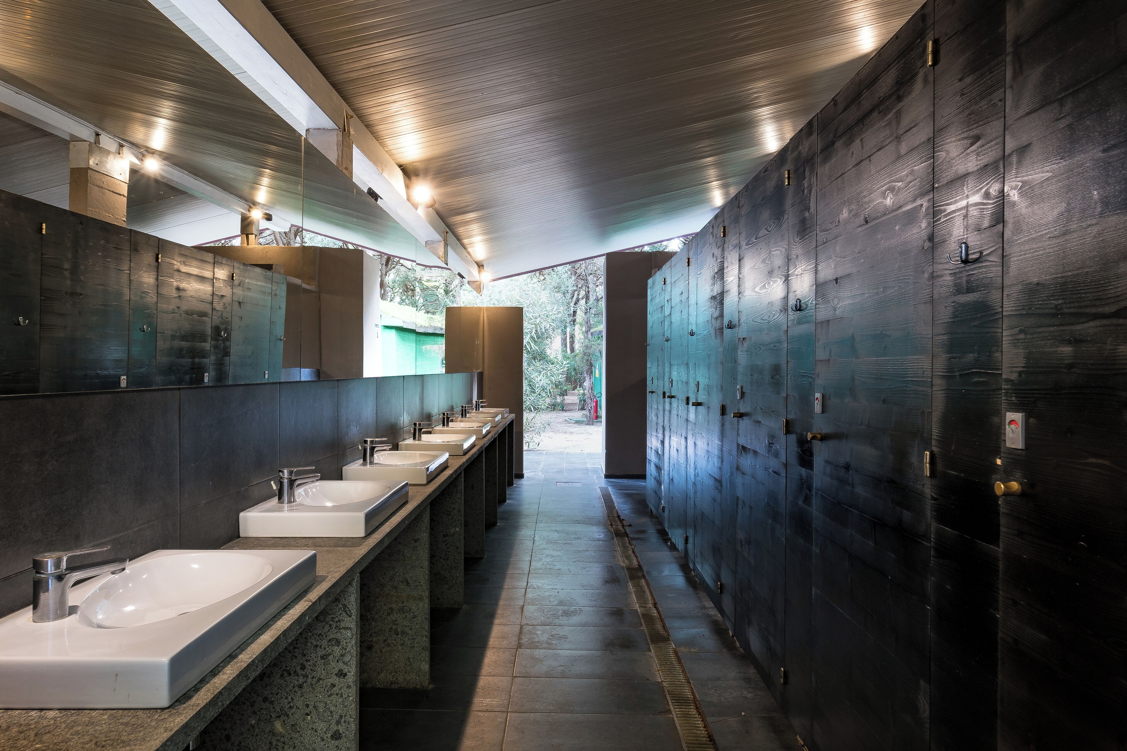 A modern bathroom with multiple sinks and lockers.