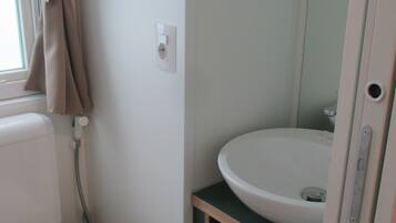 Un bagno piccolo con il water, un lavandino e uno specchio.
