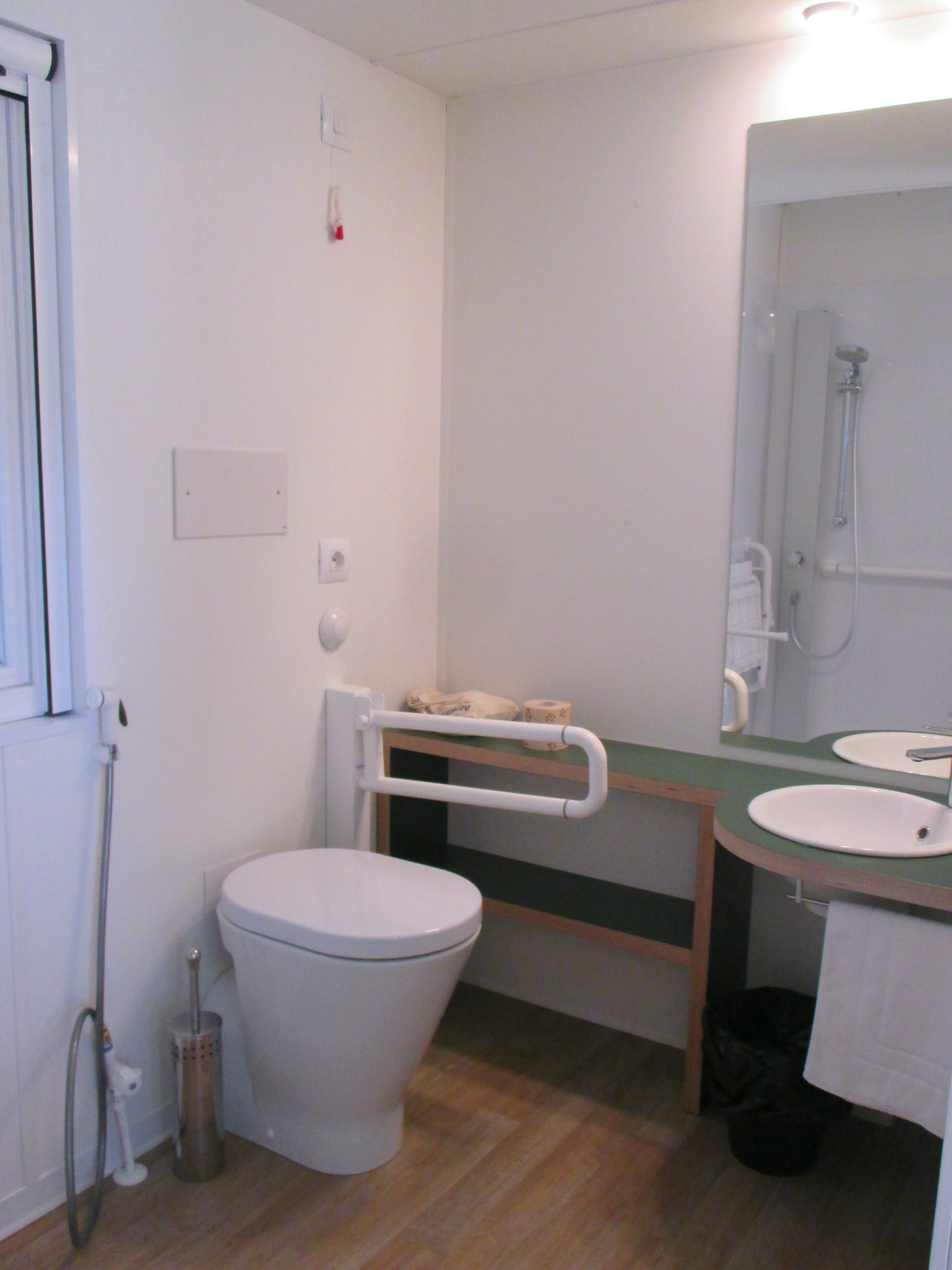 Un bagno piccolo e pulito, con toilette, lavandino e doccia.