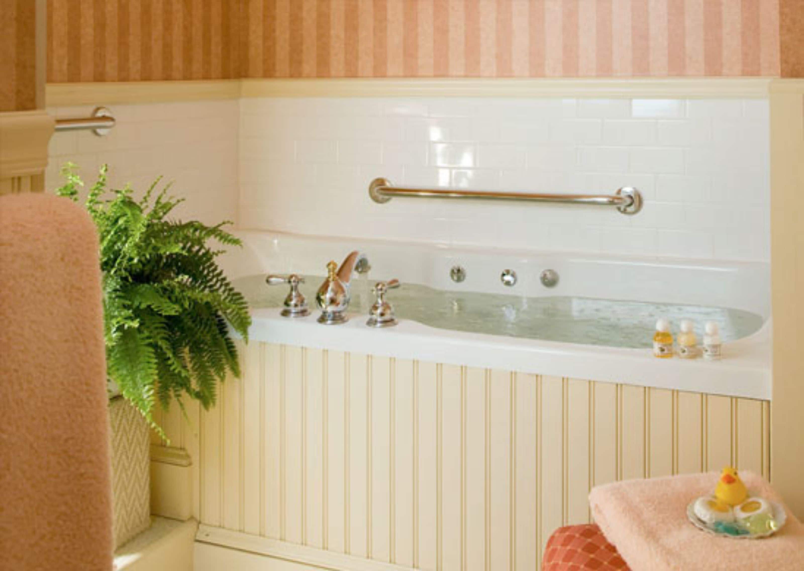 A bathroom with a bathtub, a towel rack, and toiletries.
