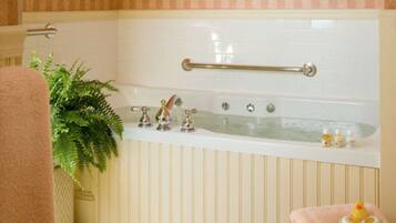 A bathroom with a bathtub, a towel rack, and toiletries.