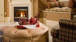 A cozy living room with a fireplace, plush seating, and a decorative giraffe. - Berry Manor Inn (Rockland)