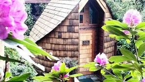 Uma cabana de madeira com uma placa indicando 'Ruka Terapi' na frente.