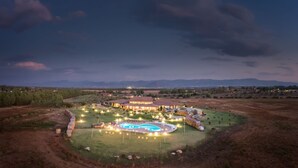 Una extensa propiedad con varias edificaciones, piscina y césped bien cuidado.