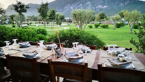 Una mesa de comedor al aire libre con vistas a la montaña.