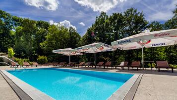 Een buitenzwembad, parasols voor strand/zwembad