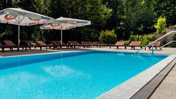 Een buitenzwembad, parasols voor strand/zwembad