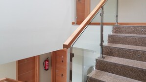 Una escalera moderna con barandillas de cristal y escalones de madera.