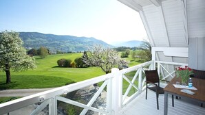 A balcony with a view of a green landscape and mountains. - Hotel Drachenwand - Mondsee (Sankt Lorenz)