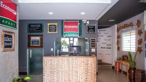 A reception desk with a check-in virtual sign, a '24-hour silence' sign, and a 'No smoking' sign. - Economy Apart (Natal)