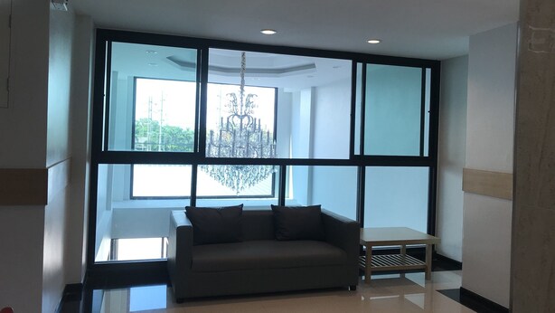 A modern room with a large window, a sofa, and a small table.