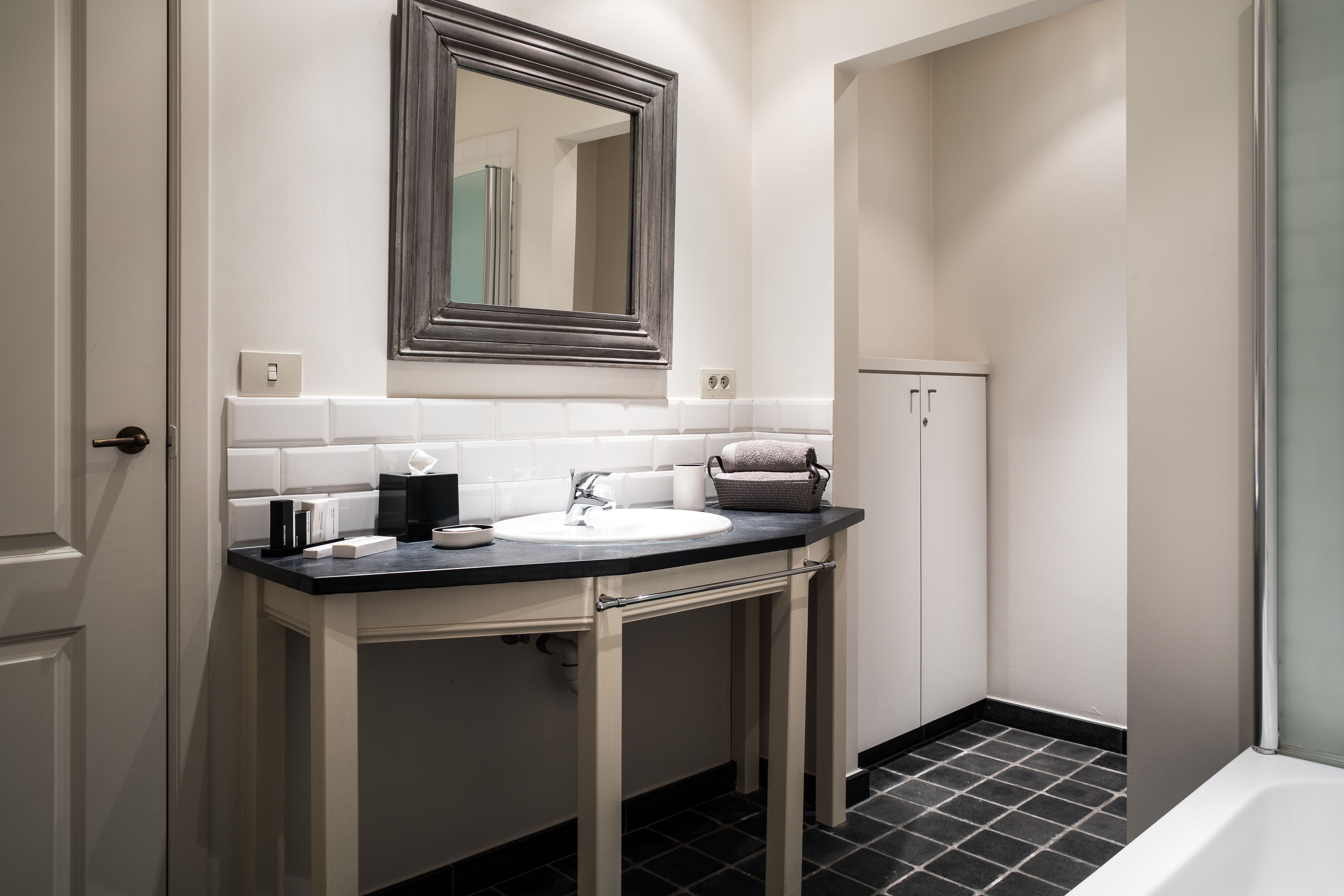 A bathroom with a white sink, a mirror, and a cabinet.