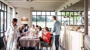 A dining area with a table set for a meal, large windows, and a view of the outdoors. - Holiday Home Babillie (Roeselare)
