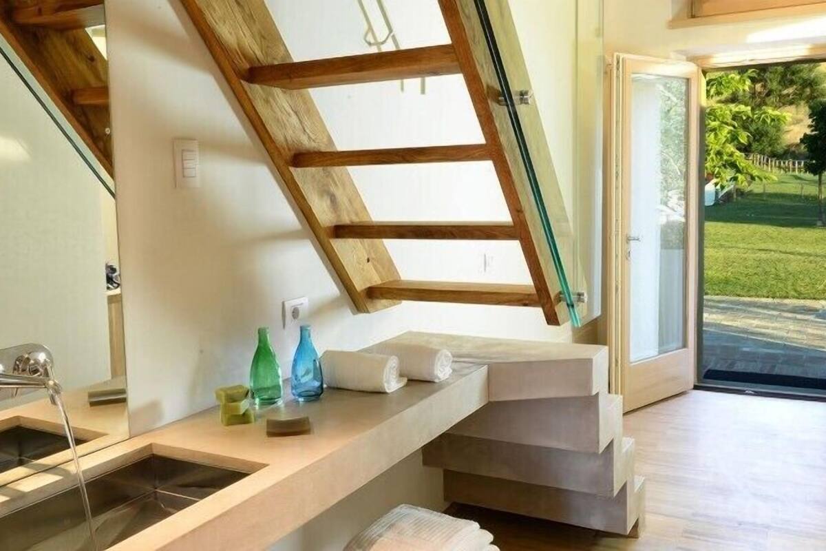 A bathroom with a skylight, a sink, and a shower.