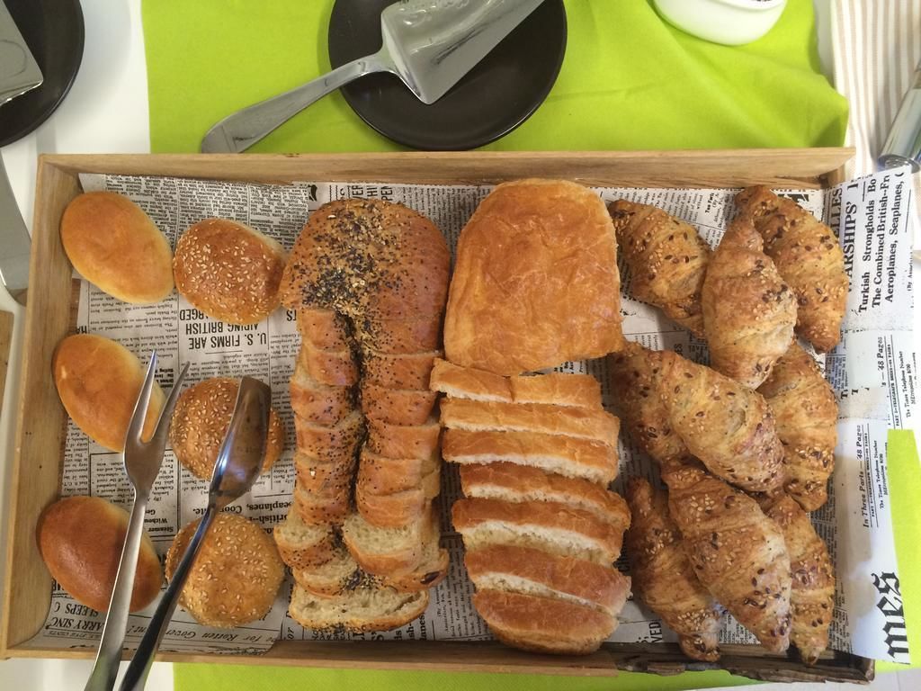 Una bandeja con pan y pastelería sobre un superficie forrada con periódico.