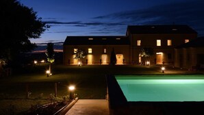Un edificio moderno con piscina al atardecer.