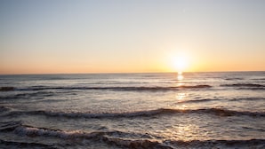 Un atardecer sobre el océano con olas.