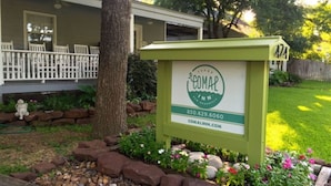 A sign for a hotel named 'Comal Inn' with contact information and a website URL.