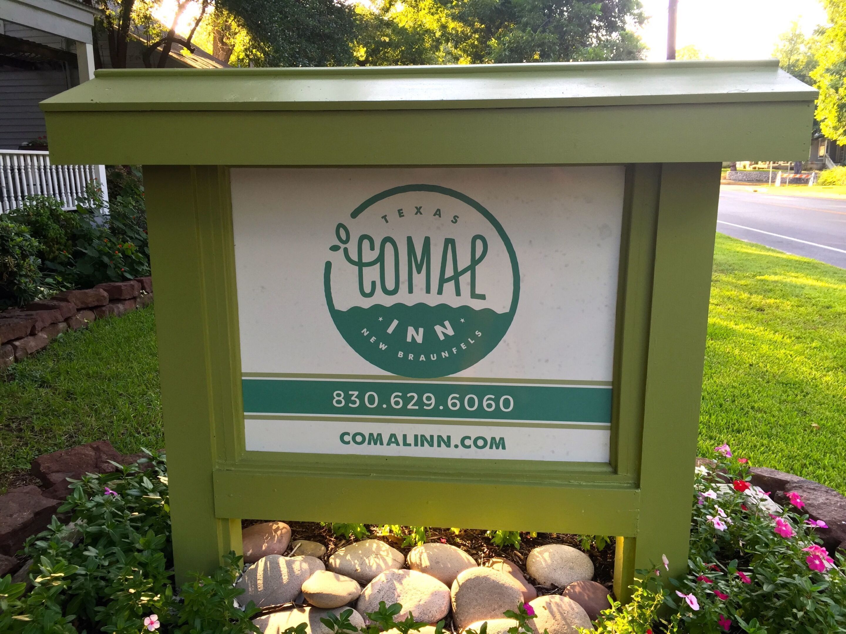 A sign for Texas Comal Inn, including a phone number and website.