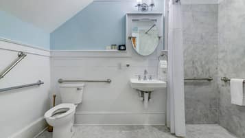 A bathroom with a toilet, sink, and shower.