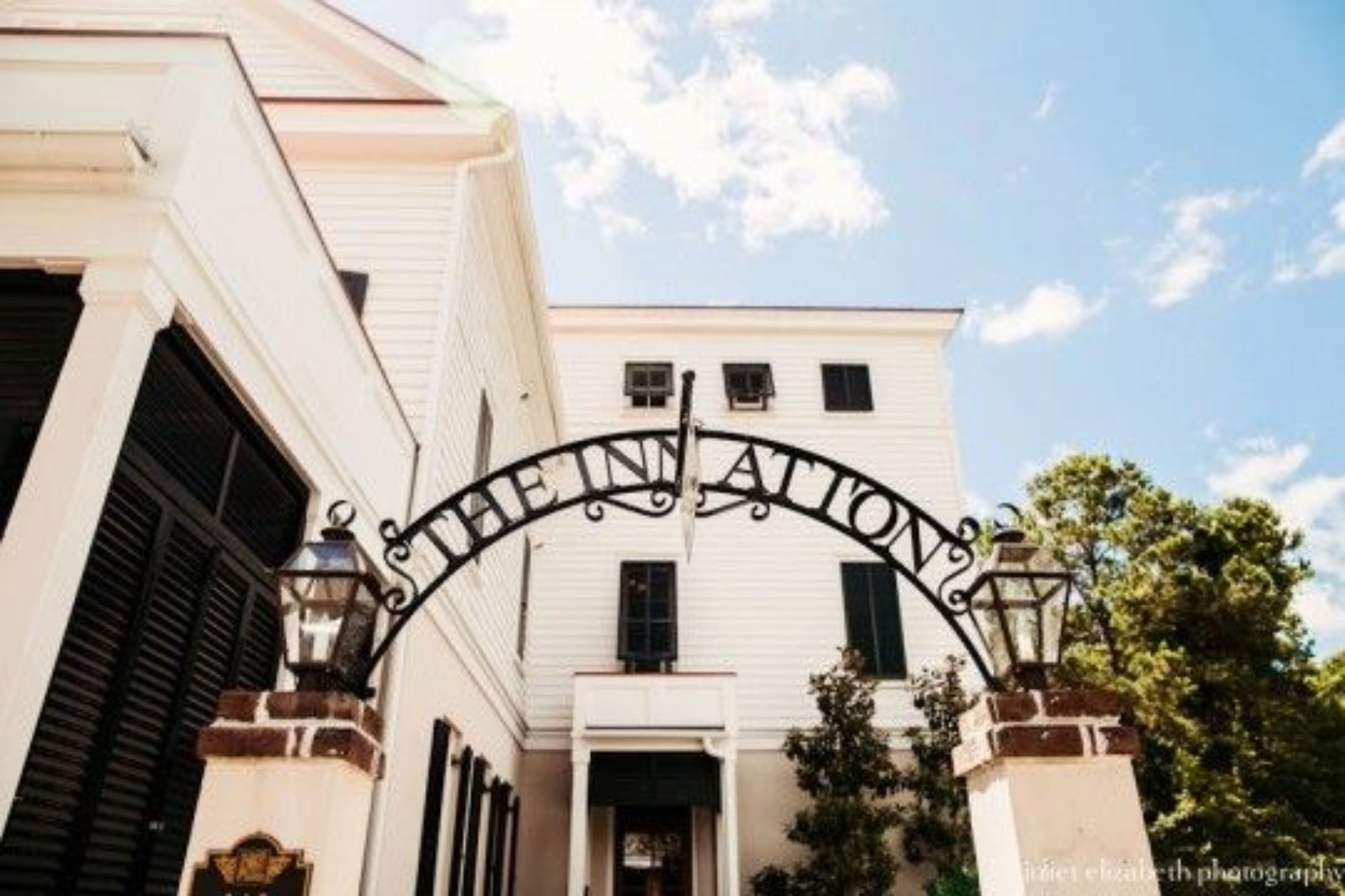 A white building with a black arched entrance sign that reads "THE INNATION".