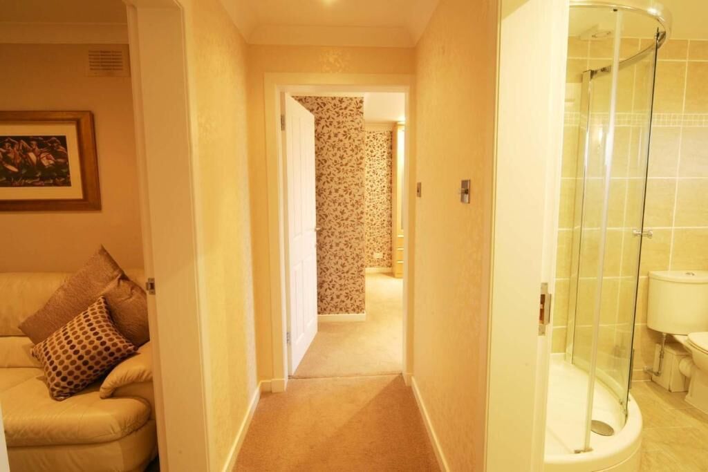 A hallway leading to a bathroom with a shower.