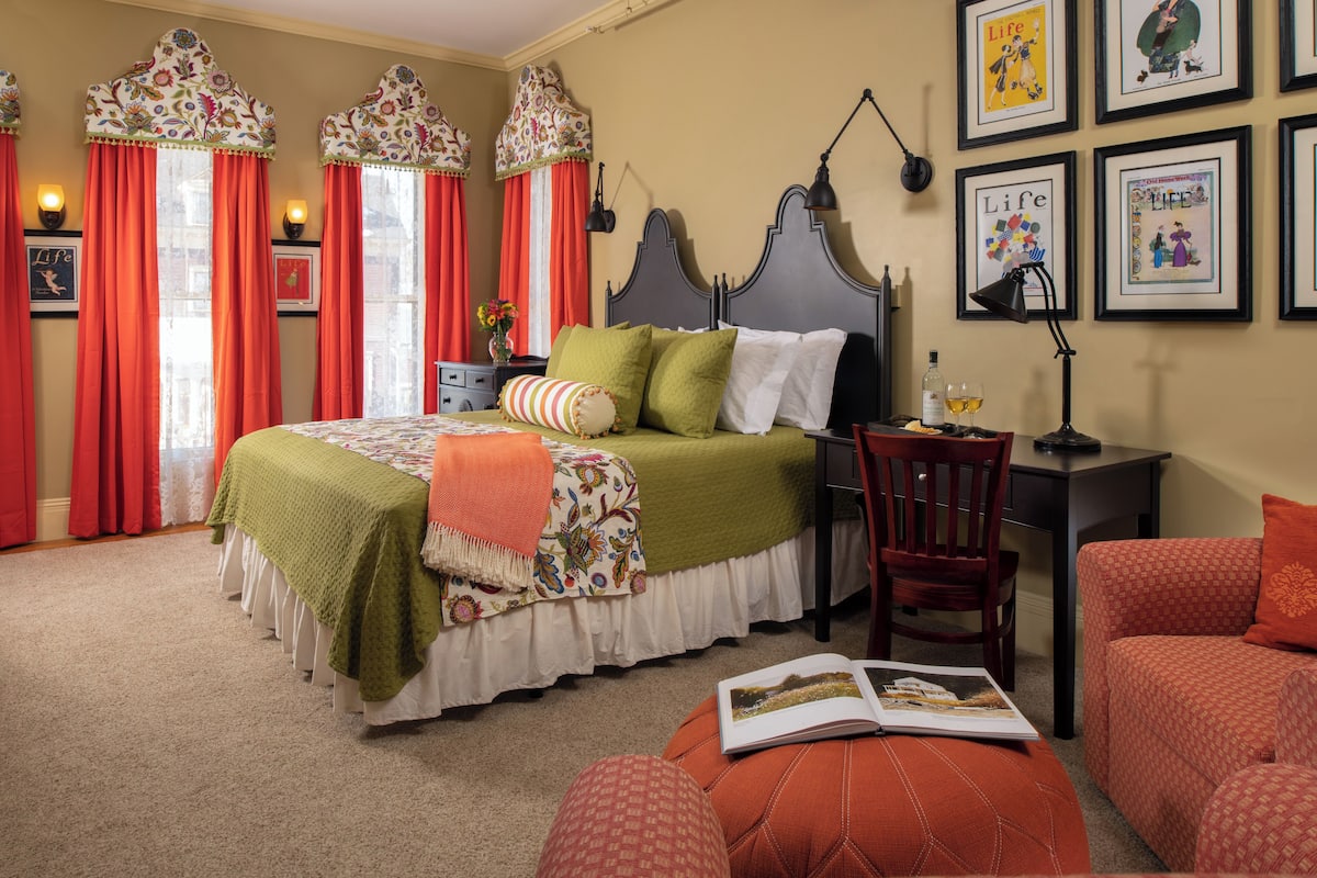 A bedroom with a bed, a desk, and a chair.