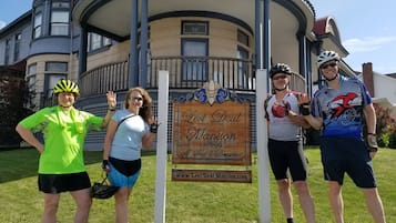 A group of people standing in front of a building with a sign that reads "Levi Deal Mansion".
