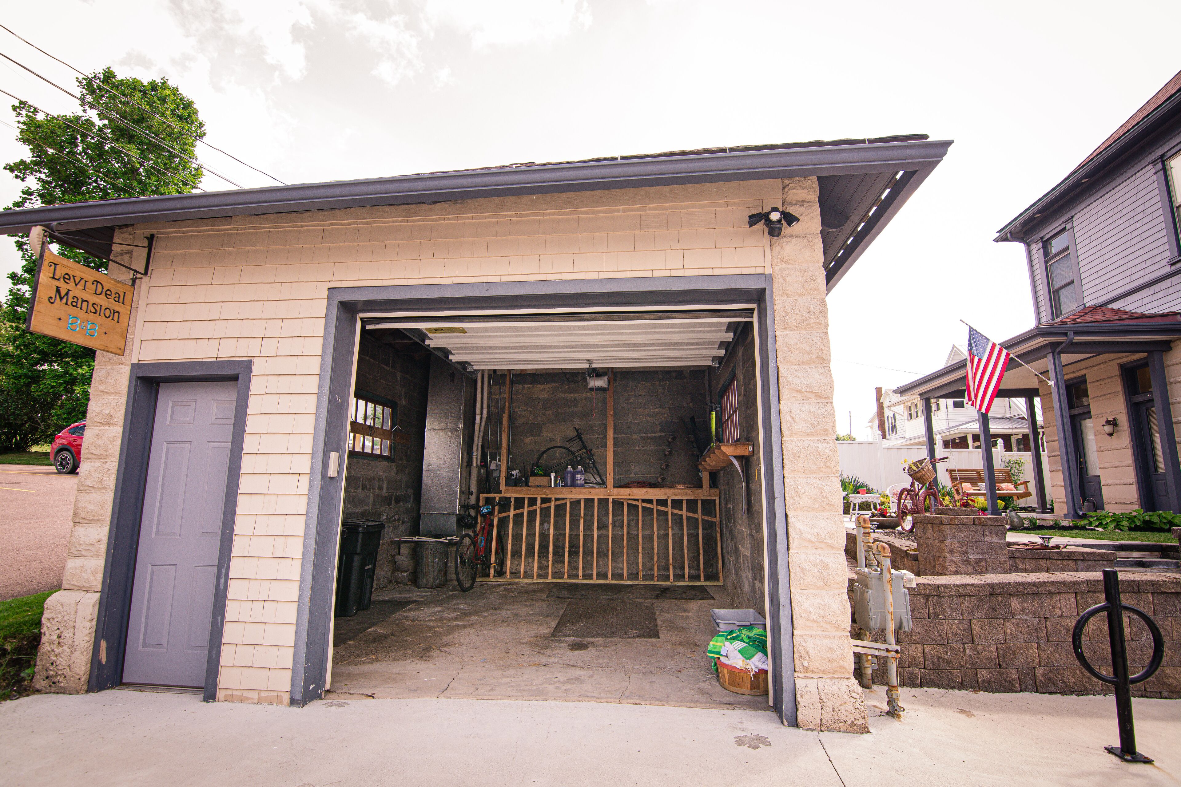 Un garage con porta chiusa, una bicicletta e un cartello che indica 'Levi-Deal Mansion'.