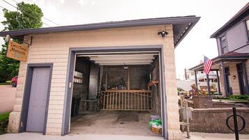 Un garage con porta chiusa, una bicicletta e un cartello che indica 'Levi-Deal Mansion'.