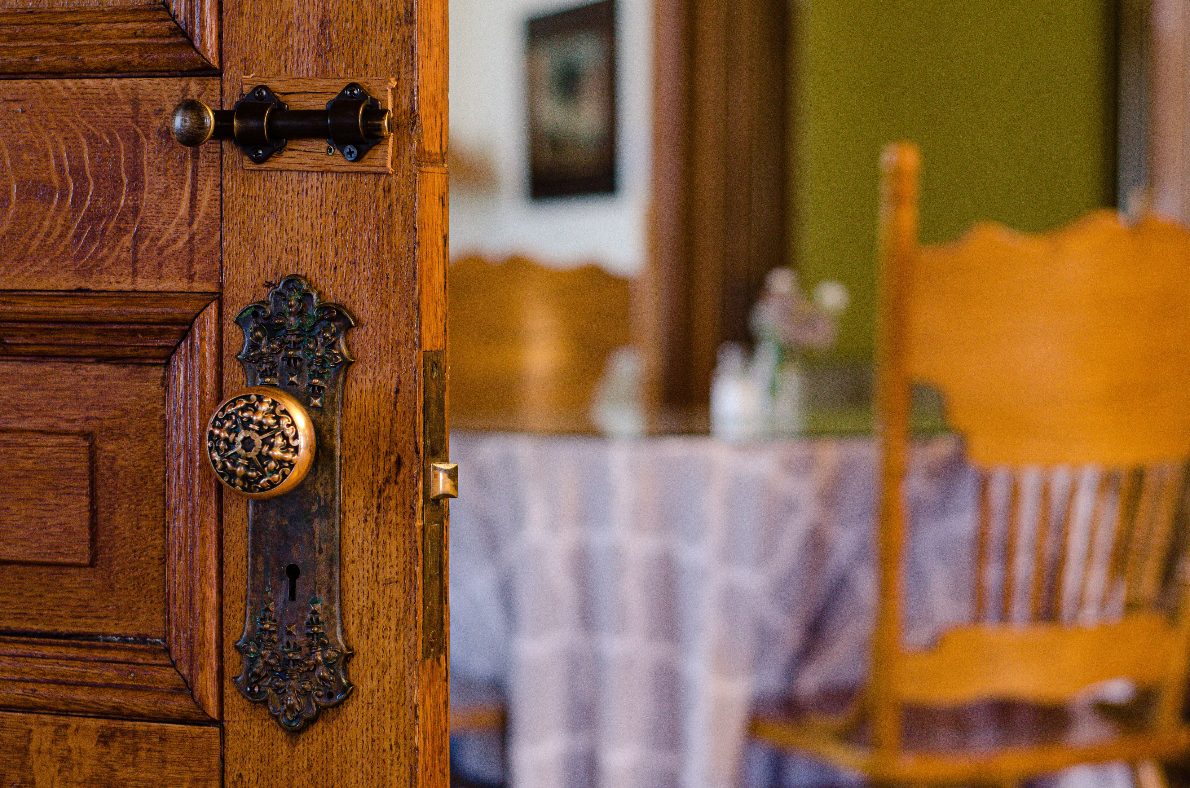 A wooden door with a brass handle and a decorative knocker.
