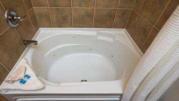 Un baño con bañera, una toalla y cortina de ducha.