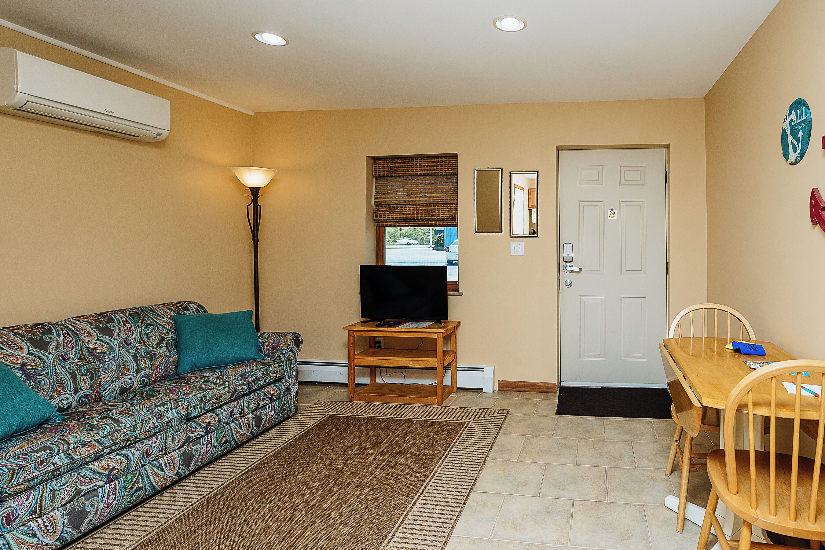 A living room with a sofa, TV stand, and dining table.