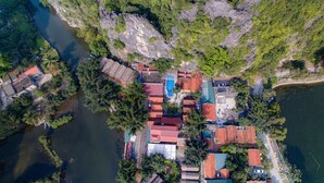 Vue aérienne d’un village riverain avec des maisons, une piscine et des bateaux.