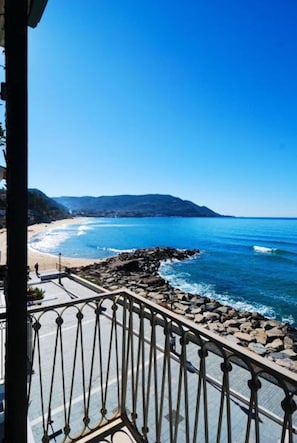 Un balcon avec vue sur une plage et l’océan.