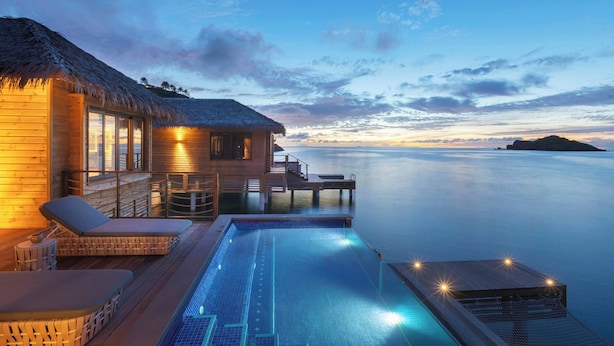 A resort with a swimming pool, lounge chairs, and a thatched-roof building. - Royalton Antigua, An Autograph Collection All-Inclusive Resort (St. John's)