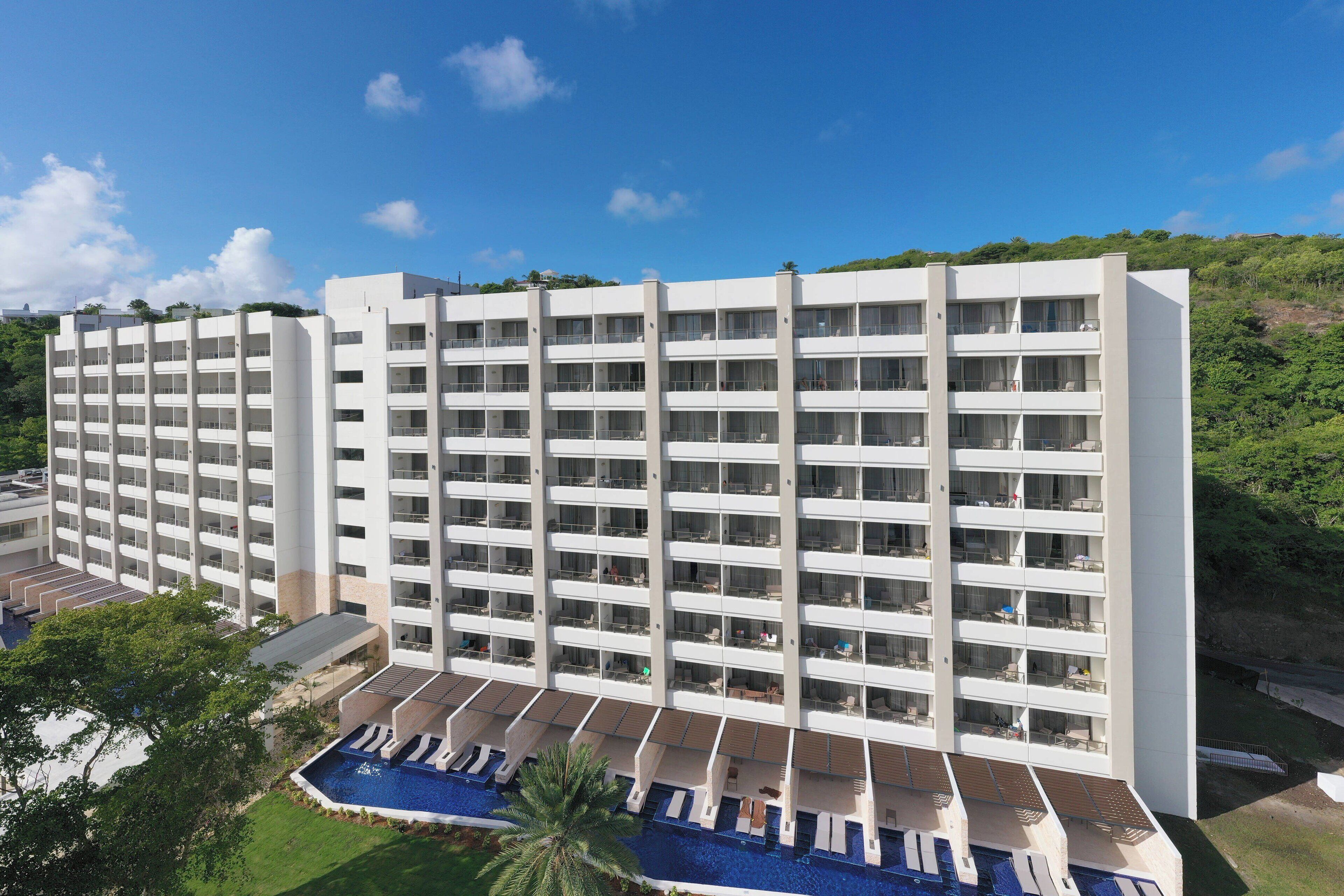 A multi-story hotel with a pool area and balconies.