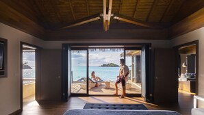 A bedroom with a large bed, a sliding glass door leading to a balcony with a view of the sea. - Royalton Antigua, An Autograph Collection All-Inclusive Resort (St. John's)