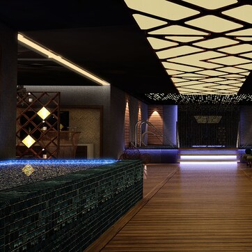 A modern spa area with wooden flooring, a reception desk, and a row of massage chairs.