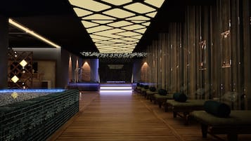 Experience comfort and elegance in our lobby, featuring a long reception desk, cushioned seating, and a unique geometric ceiling design.