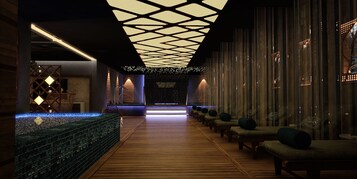 Un área de spa moderna con suelo de madera, un mostrador de recepción y una fila de sillas de masaje.