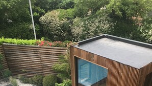 A modern outdoor deck with a pool, lounge chairs, and a barbecue grill. - Urbanhouse Cocoon Studio (Toulouse)