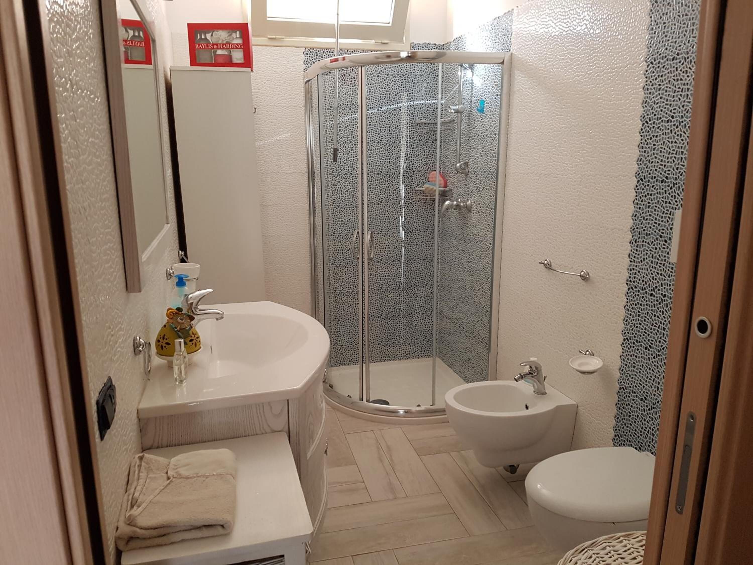 A bathroom with a bathtub, a shower enclosure, a toilet, and a sink.