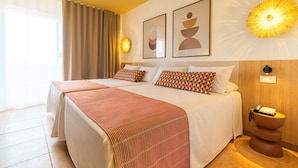 Habitación de hotel con una cama grande, una mesita de noche con teléfono y una lámpara de pared.